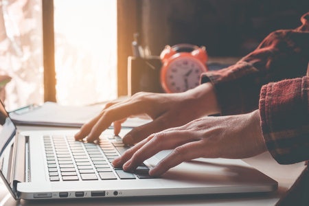 Man's using laptop with blank screen on desk in home interior. Business conceptの写真素材