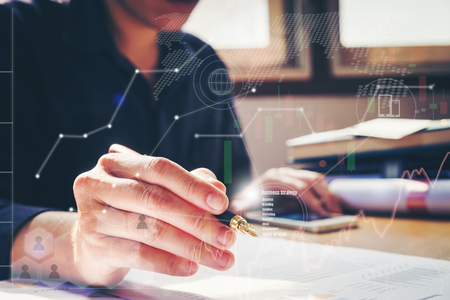 business documents on office table with smart phone  graph financial with social network diagram and man working in the backgroundの写真素材