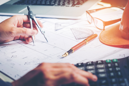 Architect or engineer working in office on blueprint. Architects workplace , blueprints, ruler, helmet and divider. Construction concept. Engineering toolsの写真素材