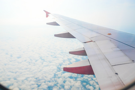 View from airplane window. Wing of an airplane flying above the cloudsの写真素材
