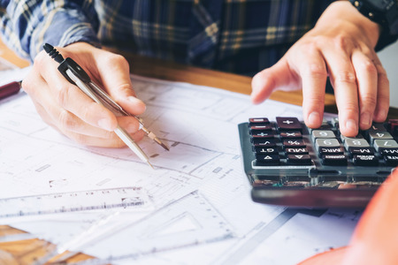 Architect or engineer working in office on blueprint. Architects workplace , blueprints, ruler, helmet and divider. Construction concept. Engineering toolsの写真素材