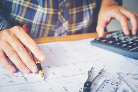 Architect or engineer working in office on blueprint. Architects workplace , blueprints, ruler, helmet and divider. Construction concept. Engineering toolsの写真素材