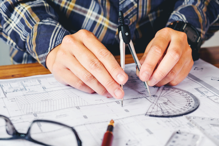 Architect or engineer working in office on blueprint. Architects workplace , blueprints, ruler, helmet and divider. Construction concept. Engineering toolsの写真素材