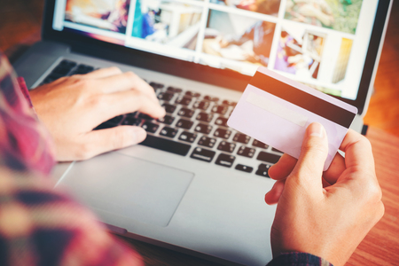 Man's hands typing laptop keyboard and holding credit card online shopping  concept.の写真素材