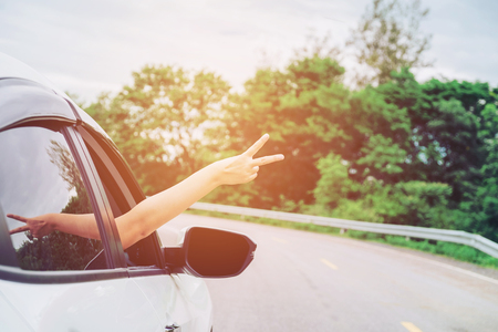 Happy beautiful girl traveling in a hatchback carの写真素材
