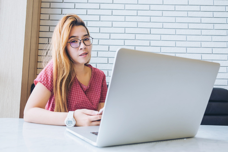 Asian girl working at a coffee shop with a laptop.female freelancer connecting to internetの写真素材