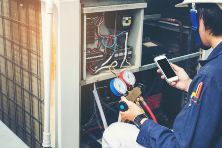 Technician is checking air conditionerの写真素材