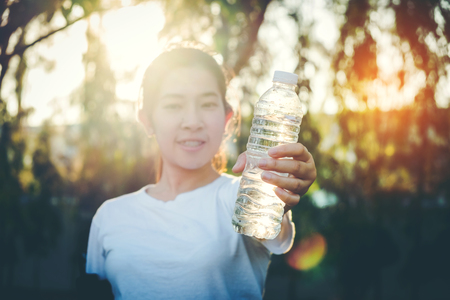 Fitness beautiful woman drinking water and sweating after exercisingの写真素材