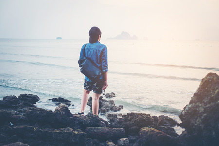 Man turned back to the camera looking at the sea, relaxed, concept of freedomの写真素材