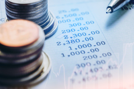 financial analyzing concept Pen and coin and on paper report.の写真素材