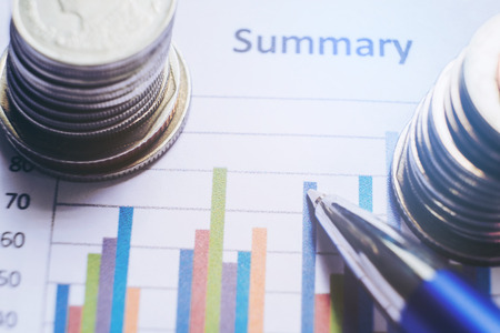 financial analyzing concept Pen and coin and on paper report.の写真素材