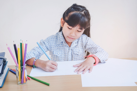 Happy school children drawing with crayonsの写真素材