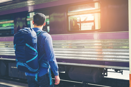 Traveler man  waits train on railway platformの写真素材