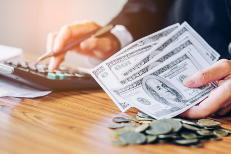 Savings economy concept  man with calculator counting money Dollar and making notes at home