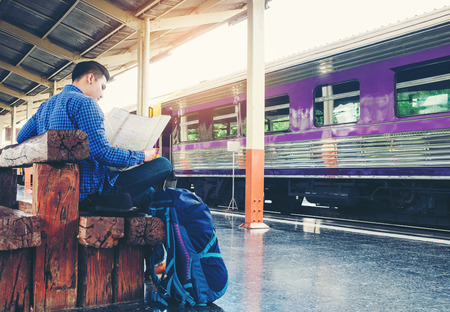 Tourist backpacker using map to travel at train stationの写真素材