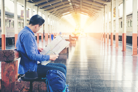 Tourist backpacker using map to travel at train stationの写真素材