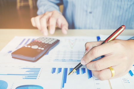 Businessman's hands with calculator at the office and Financial data analyzing countingの写真素材