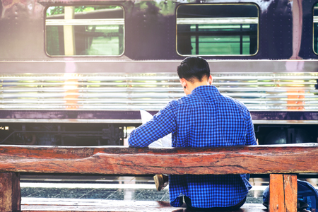 Tourist backpacker using map to travel at train stationの写真素材