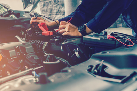 Auto mechanic checking car battery voltageの写真素材