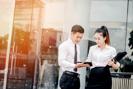 Asian Business couple meeting Using digital tablet outdoor after workの写真素材