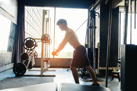 Fitness Strong Man Doing Heavy Weight Exercise on Machine in gymの写真素材