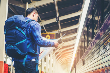 Tourist backpacker using map to travel at train stationの写真素材