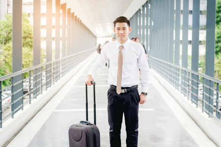 Professional businessman Travel  smiling happy outside walking inside in airportの写真素材