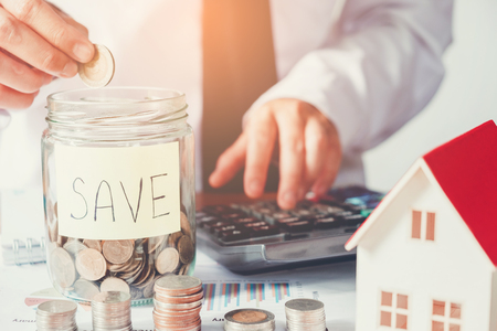 Man using calculator Save money for home costの写真素材