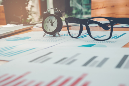 Glasses and clock on the business paper. Report chartの写真素材