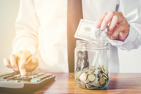 Saving money concept Man hand putting Row and coin Write Financeの写真素材