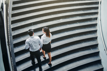 Businessman and Business woman go up the stairs Success conceptの写真素材