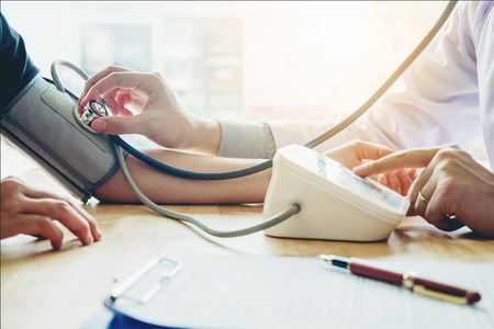 Doctor Measuring arterial blood pressure woman patient on arm Health care in hospitalの写真素材