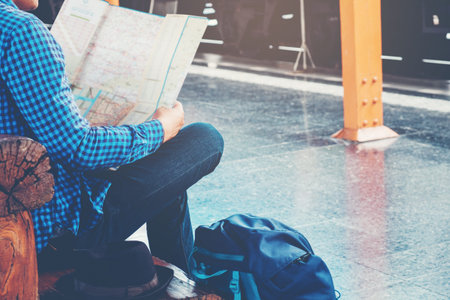 Tourist backpacker using map to travel at train station