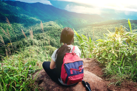 Young tourist woman backpacker at sunrise view of  mountain peakの写真素材
