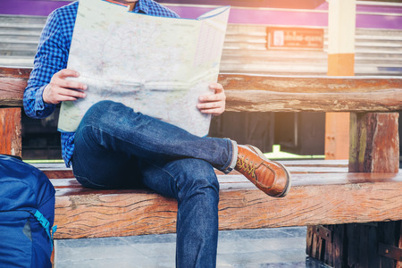 Tourist backpacker using map to travel at train stationの写真素材