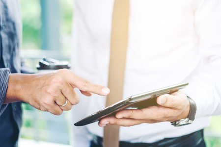 Group of Business people talking with businessman working on digital tablet in outdoor after workの写真素材