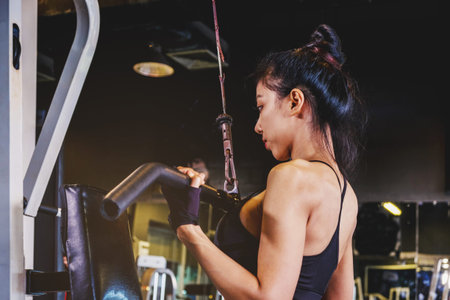 Asian young fitness woman execute exercise with exercise-machine in gym