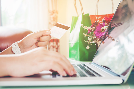 Closeup credit card ,Woman shopping online using laptop with credit card enjoying in homeの写真素材