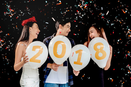 Newyear party ,celebration party group of asian young people holding balloon numbers 2018 happy and funny conceptの写真素材