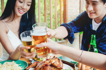 Group of young asian people celebrating beer festivals happy while enjoying home partyの写真素材