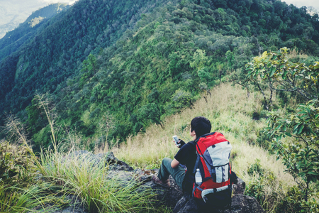 Tourist trail hiking in the forest Traveler Man with backpack crossing the mountainの写真素材