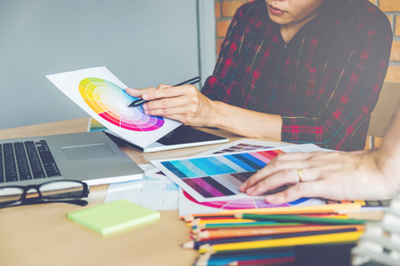 Two Graphic designer drawing on graphics tablet and color palette guide at workplaceの写真素材
