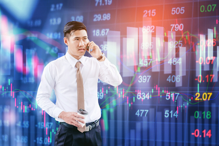 Professional businessman using smartphone  talking on his phone smiling happy on digital stock market financial exchange information and Trading graph backgroundの写真素材
