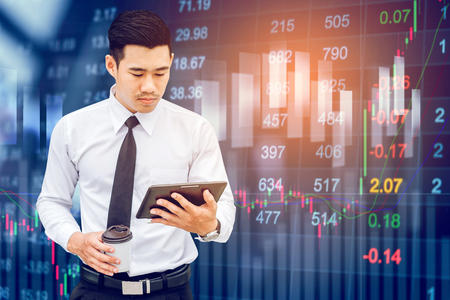 Businessman Using Digital Tablet on digital stock market financial exchange information and Trading graph backgroundの写真素材