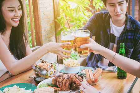Group of young asian people celebrating beer festivals happy while enjoying home partyの写真素材