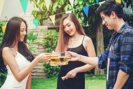 Group of young asian people celebrating beer festivals happy while enjoying home partyの写真素材