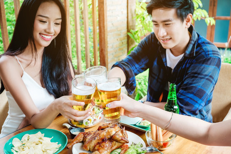 Group of young asian people celebrating beer festivals happy while enjoying home partyの写真素材
