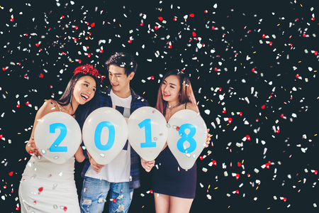 Newyear party ,celebration party group of asian young people holding balloon numbers 2018 happy and funny conceptの写真素材