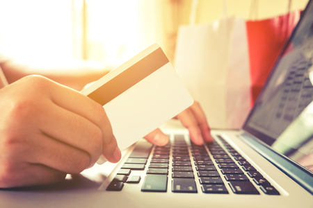 Close up credit card,woman shopping online using laptop enjoying in homeの写真素材