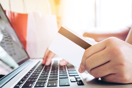 Close up credit card,woman shopping online using laptop enjoying in homeの写真素材